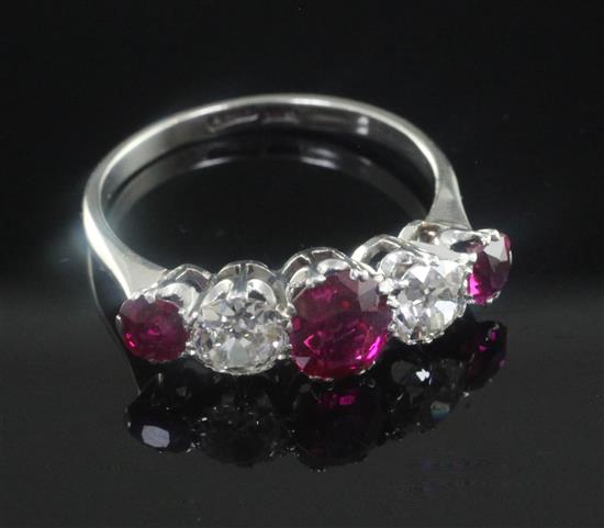 A 1940s platinum and graduated five stone ruby and diamond half hoop ring, size Q.